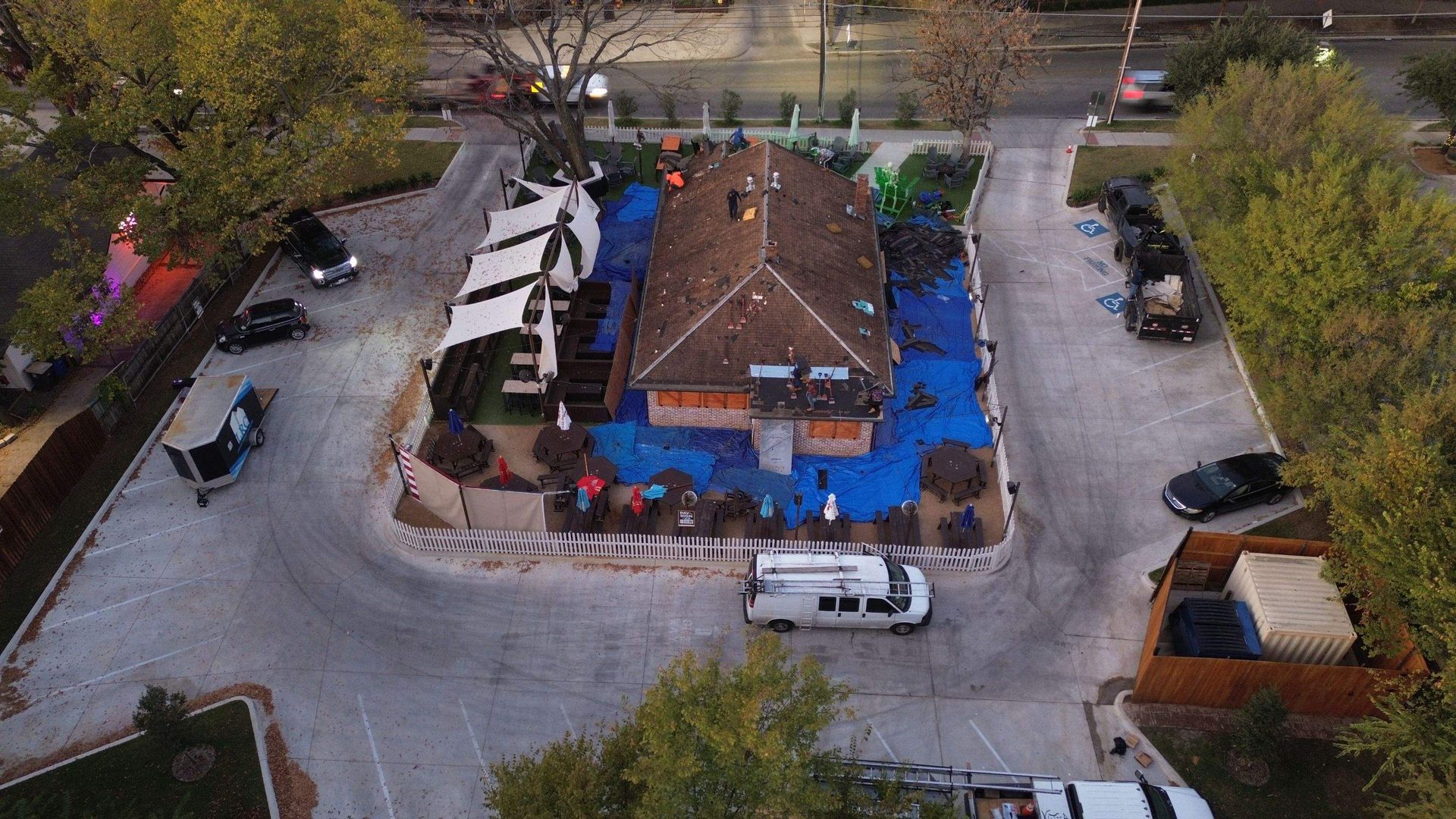 An aerial view of a building with a blue tarp on the roof.