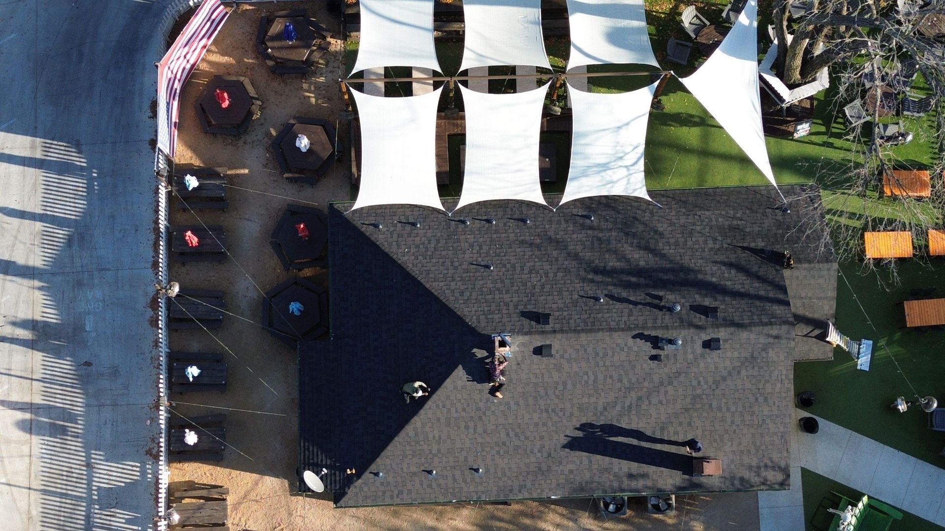 An aerial view of a house with a lot of umbrellas on the roof.