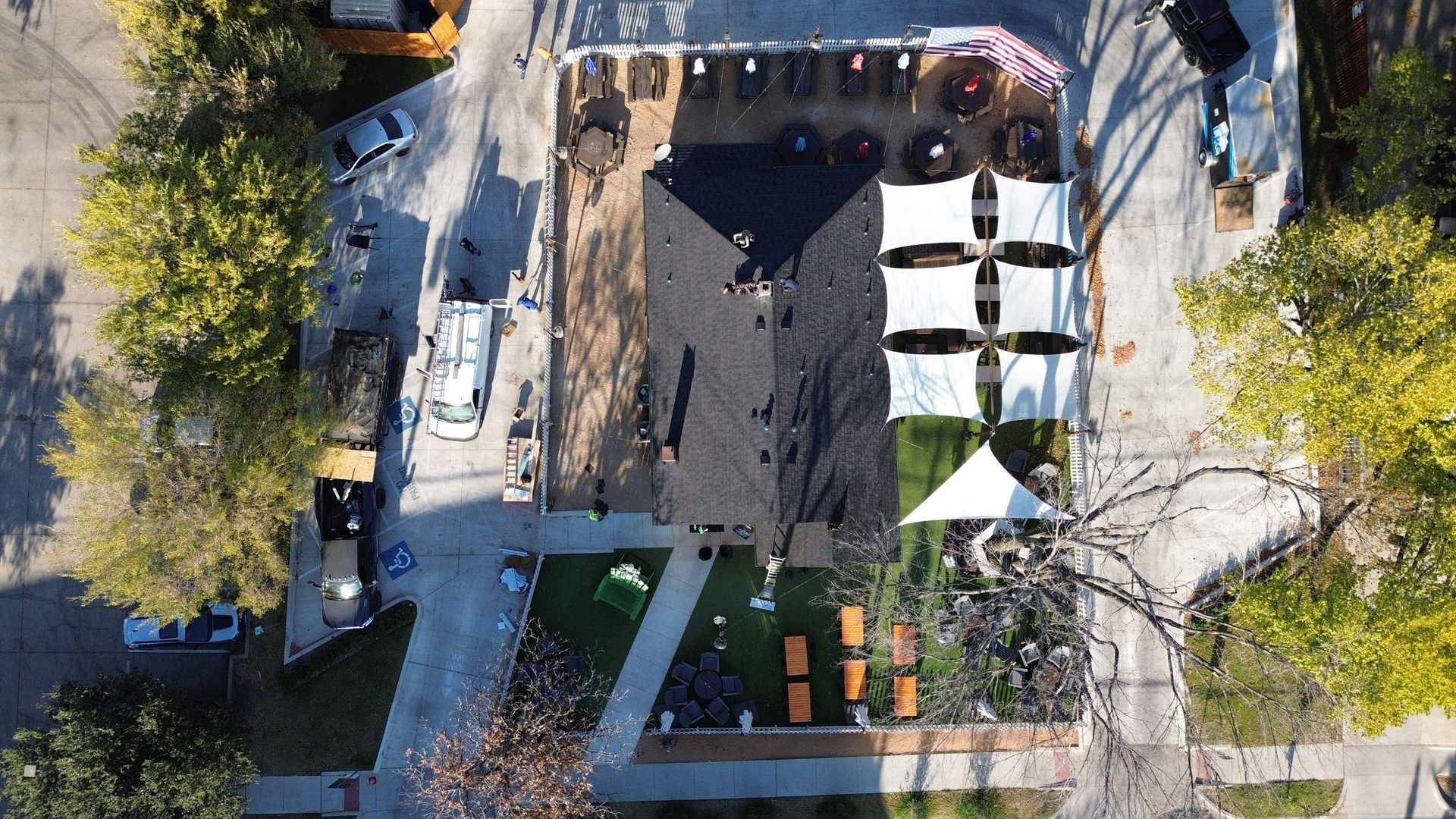 An aerial view of a park with tents and tables