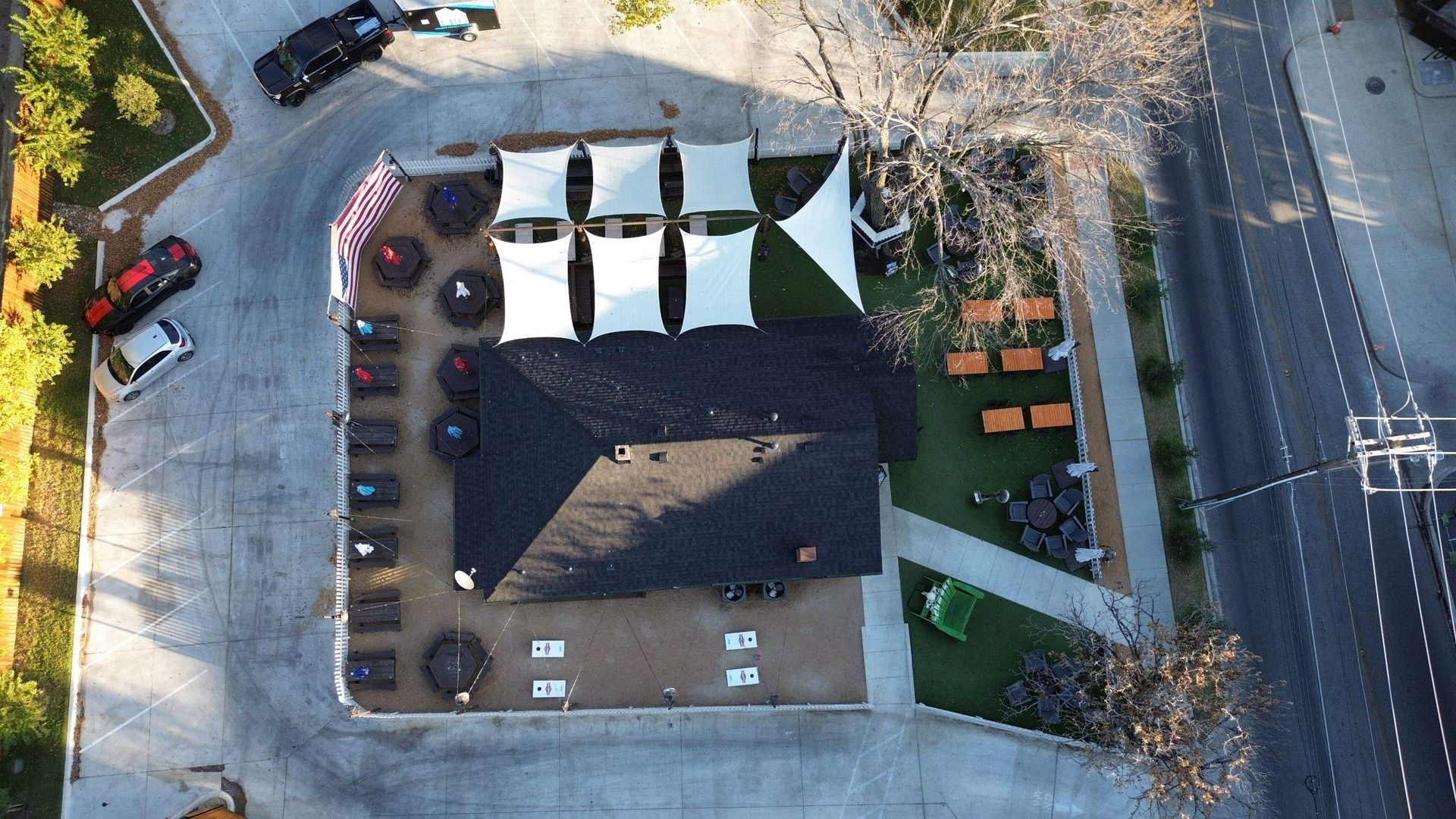 An aerial view of a parking lot with a house in the middle