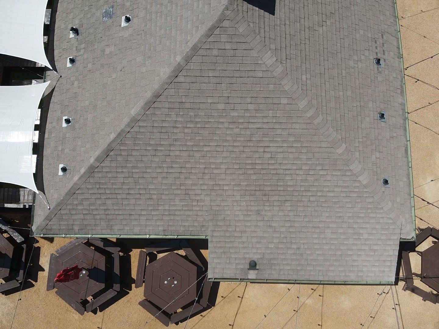 An aerial view of a house with a roof and patio furniture.