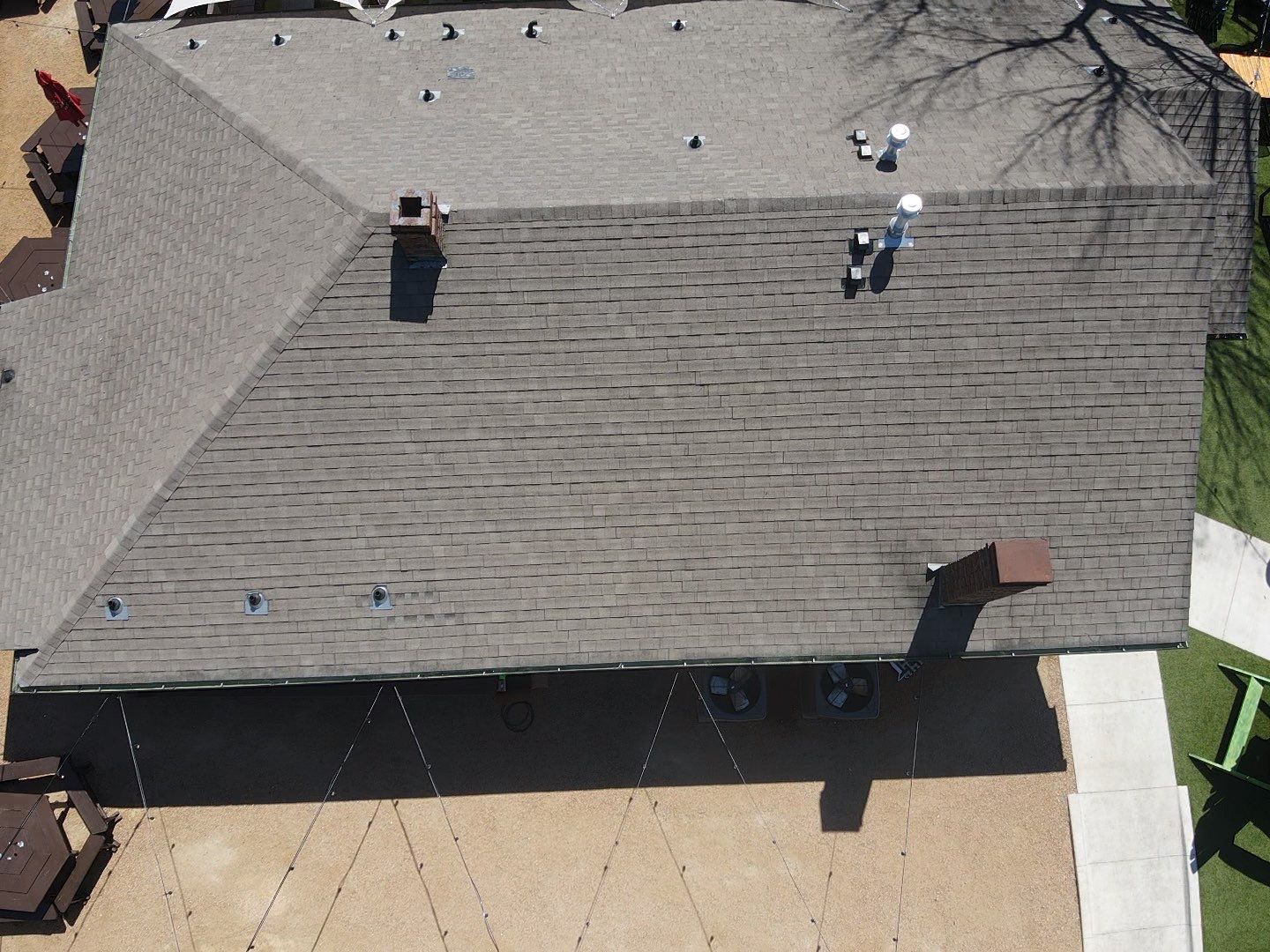 An aerial view of a house with a roof and a driveway.