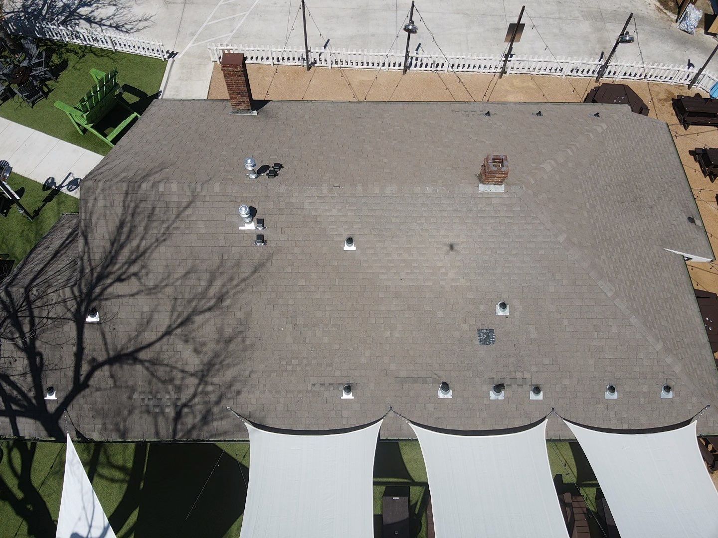 An aerial view of a roof with a few trees in the background