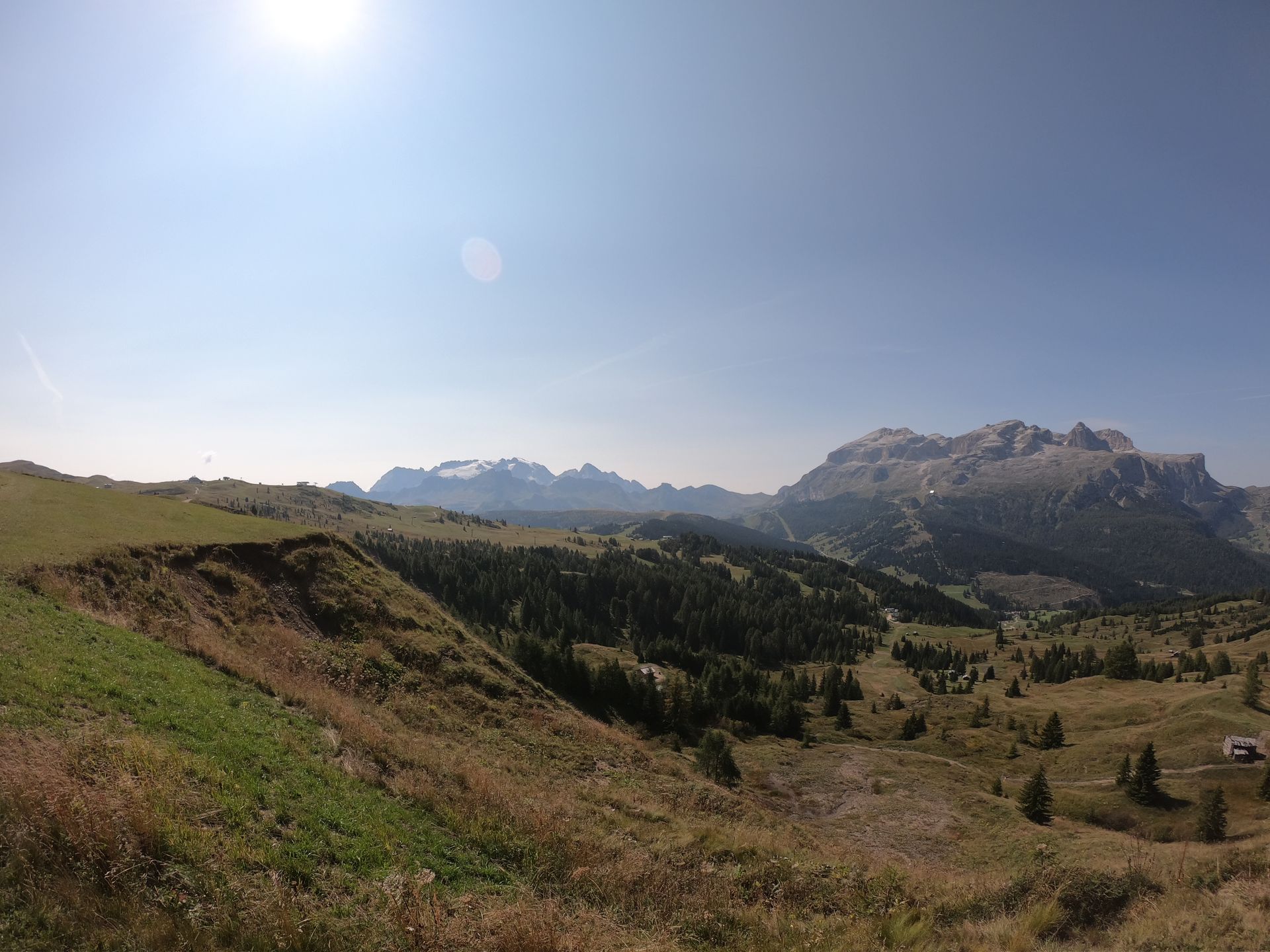A panoramic view of a mountain valley with mountains in the background.