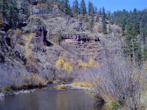 A river runs through a valley surrounded by trees and rocks.