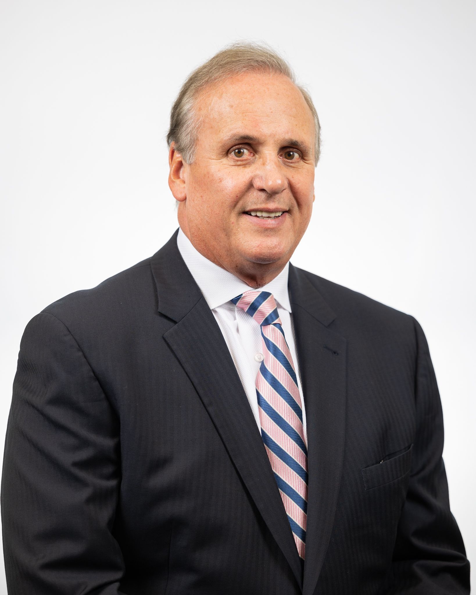 A man in a suit and tie is smiling for the camera.
