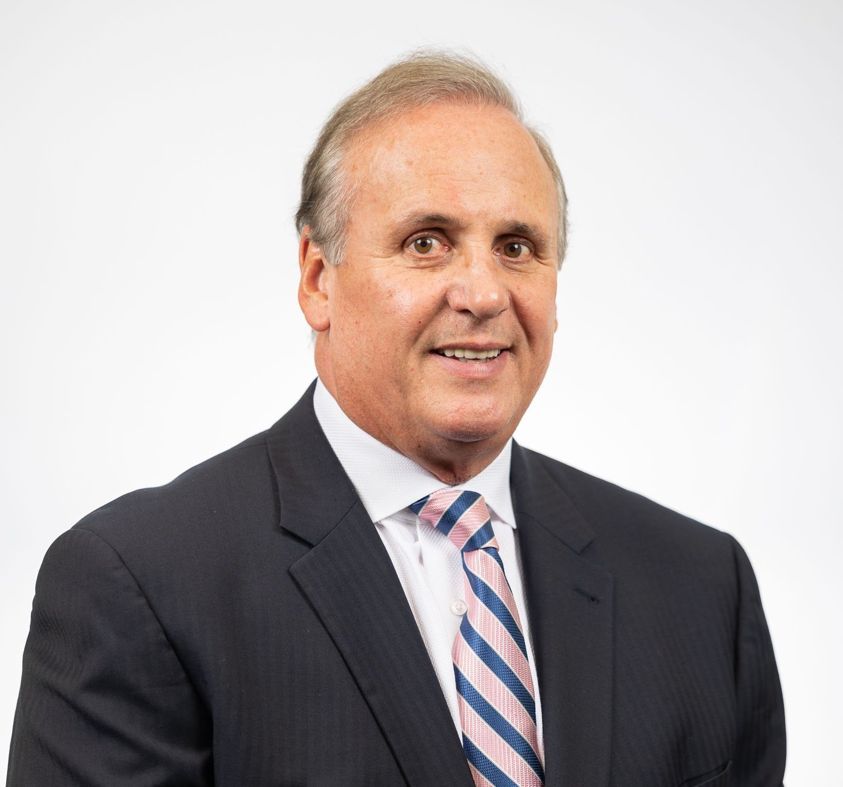 A man in a suit and tie is smiling for the camera.