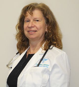 A woman is wearing a white lab coat and a stethoscope around her neck.