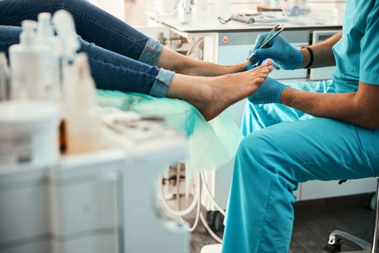 A woman is getting her feet examined by a podiatrist.