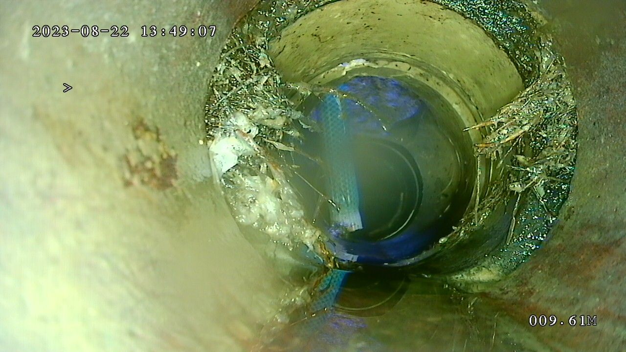 A close up of a hole in a pipe with water coming out of it.