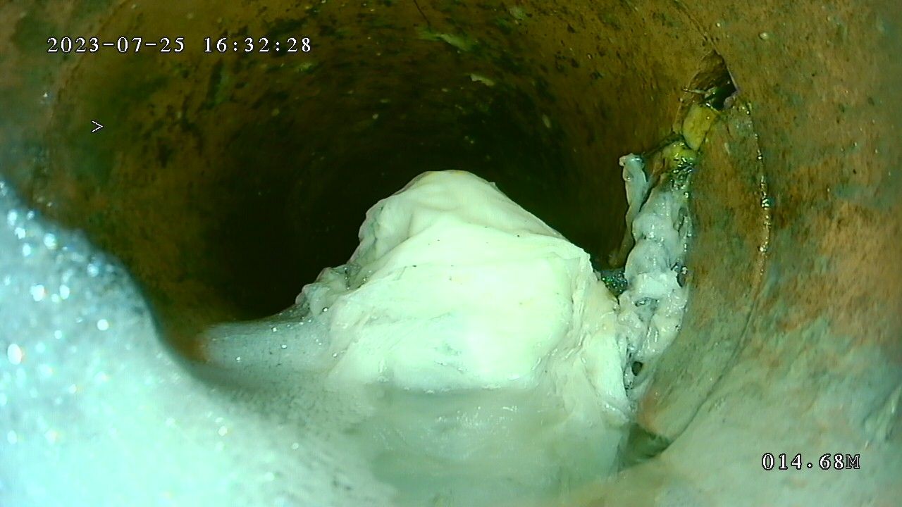 A close up of a hole in a pipe with foam coming out of it.