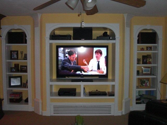 A living room with shelves and a flat screen tv