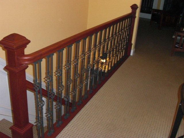 A staircase with a wooden railing and a metal railing