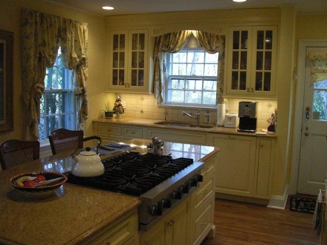 A kitchen with a large island and a stove top oven