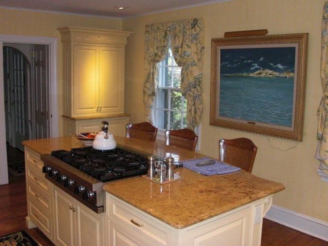 A kitchen with a large island and a painting on the wall