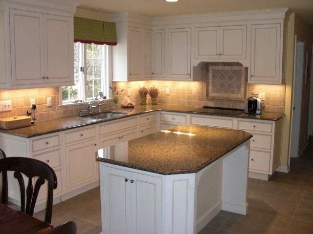 A kitchen with white cabinets and granite counter tops