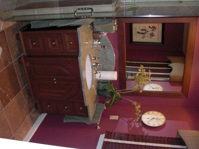 A bathroom with purple walls and a clock on the wall