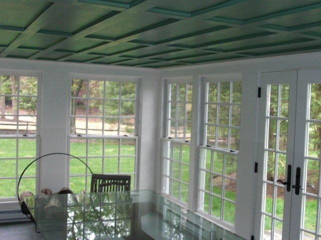 A room with lots of windows and a green ceiling