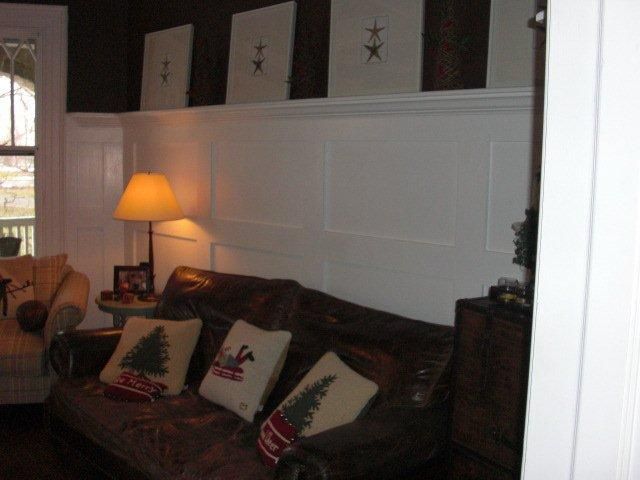 A living room with a brown couch and christmas pillows