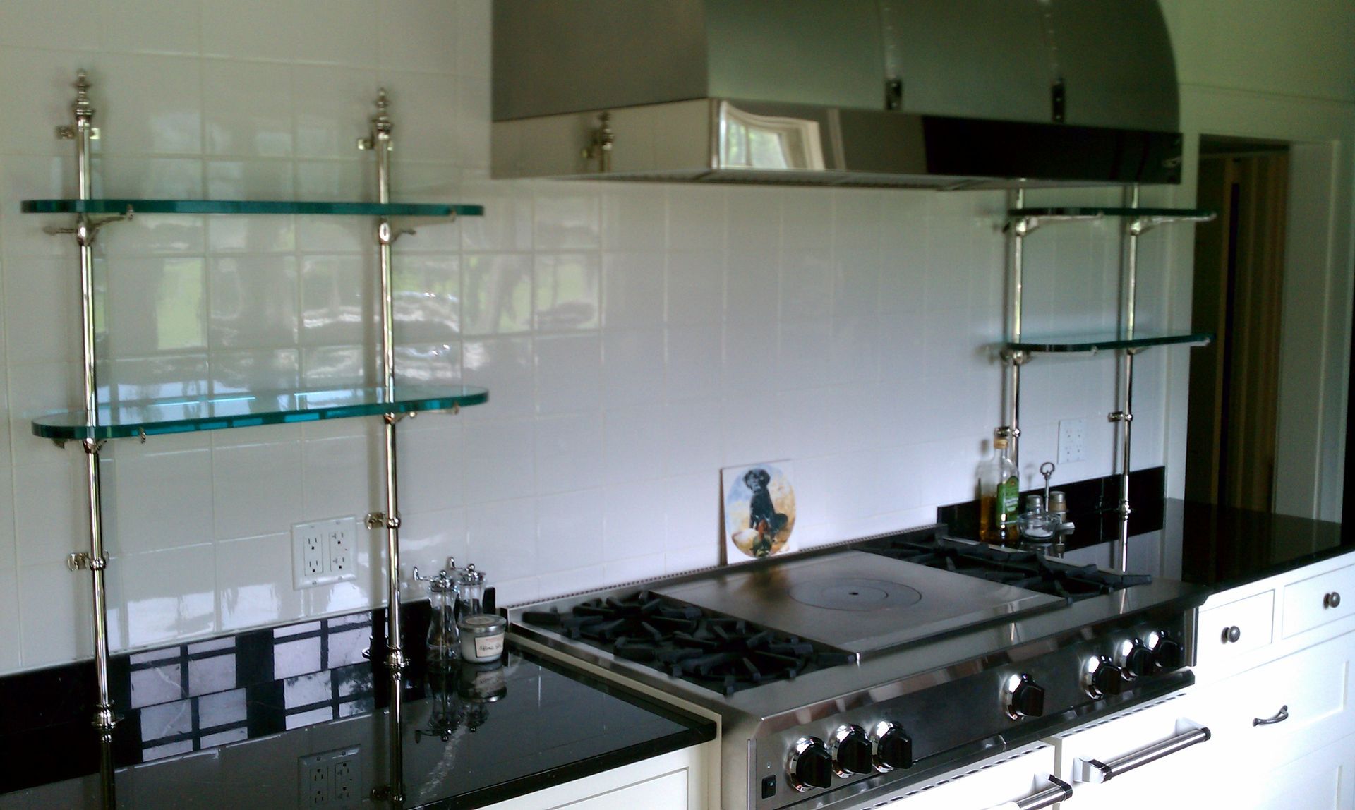 A kitchen with a stove top oven and glass shelves