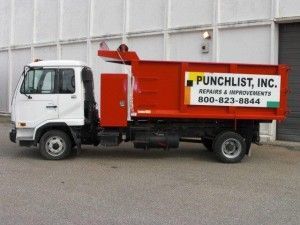 A Punchlist Inc Dump Truck is Parked in Front of a Building