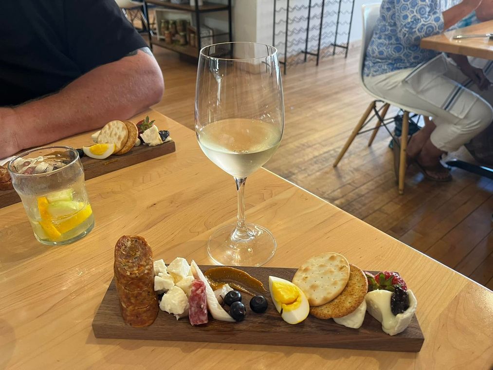 A plate of food and a glass of wine on a table.