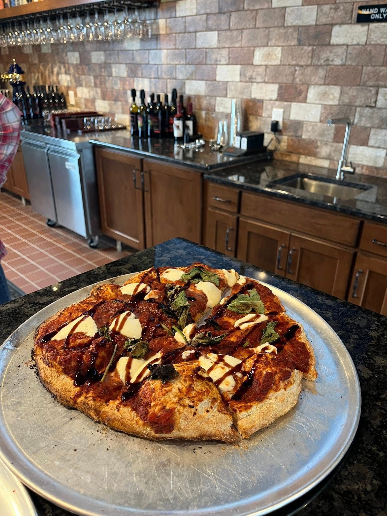 A plate of food and two glasses of wine are on a table.