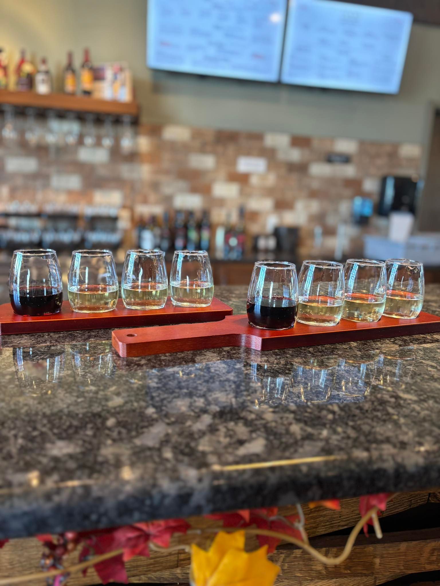 A group of people are sitting under red umbrellas at a restaurant.