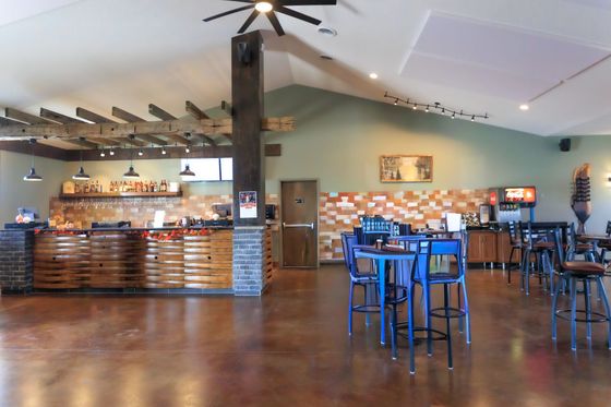 A bottle of margarita wine is sitting on a wooden barrel