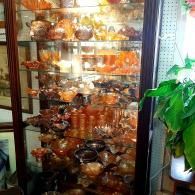 A tall wooden display cabinet filled with numerous amber-colored glass bowls, plates, and decorative items.