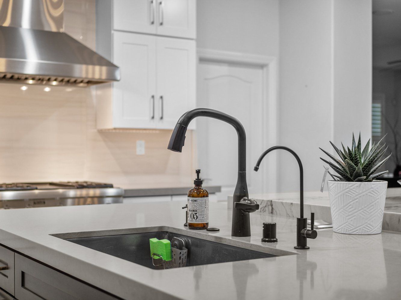 Black and bronze kitchen sink faucet fixture in Aliso Viejo, CA