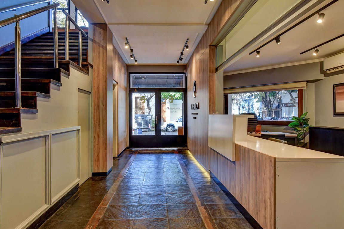 Un pasillo largo con escaleras y un mostrador en un edificio.