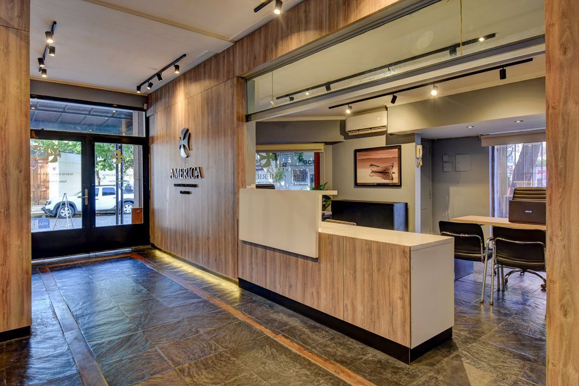 Un vestíbulo de hotel con una pared de madera y un mostrador blanco.