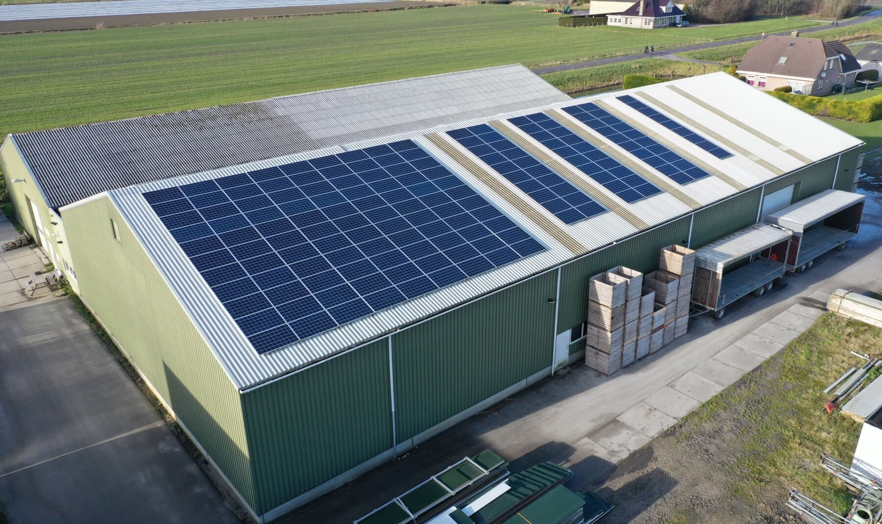 Een luchtfoto van een groot gebouw met zonnepanelen op het dak.