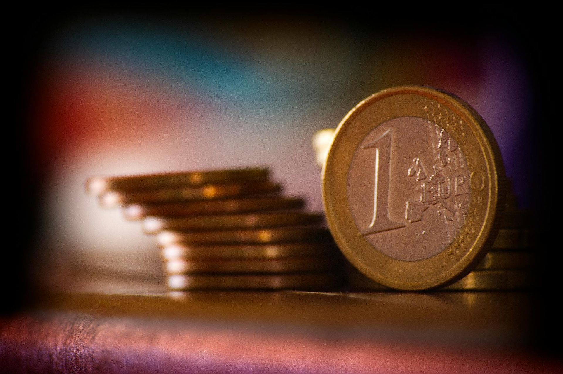 Een stapel munten met een euromunt in het midden.