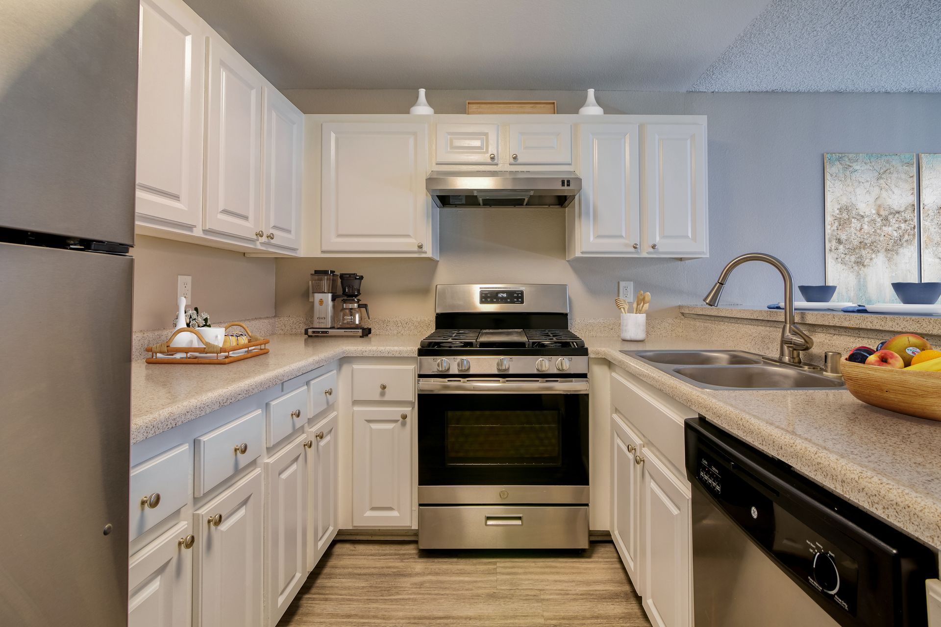 A kitchen with white cabinets and stainless steel appliances