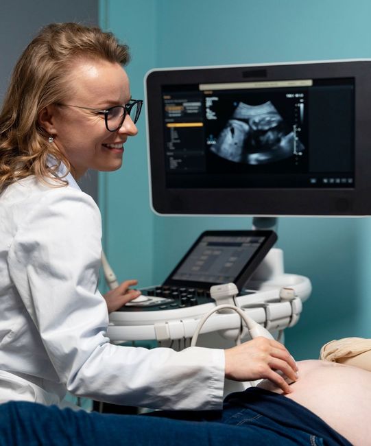 A pregnant woman is getting an ultrasound from a doctor