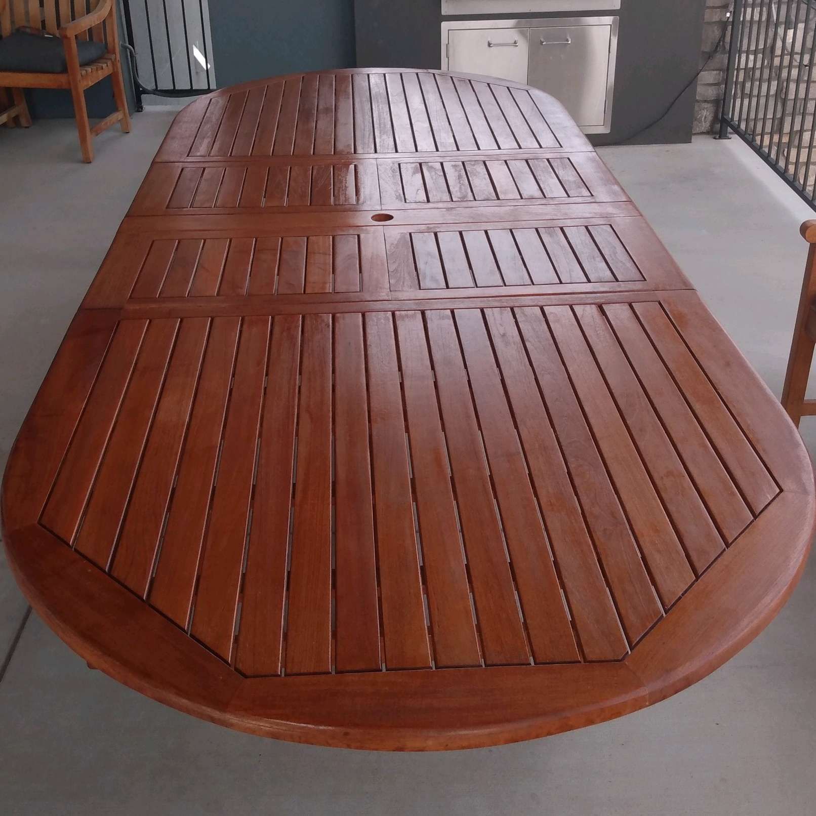 A large wooden table is sitting on a balcony