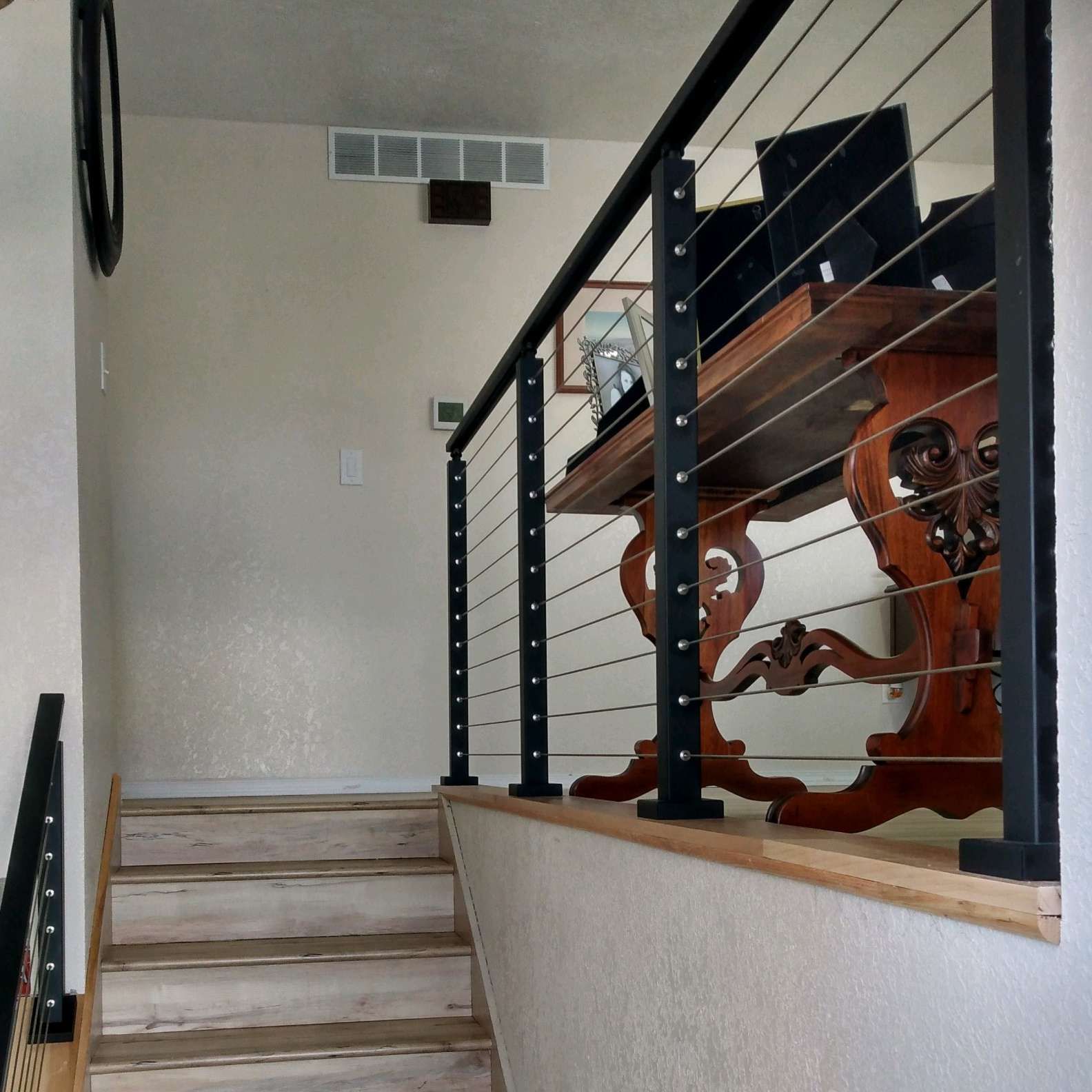 A staircase with a black railing and a wooden table