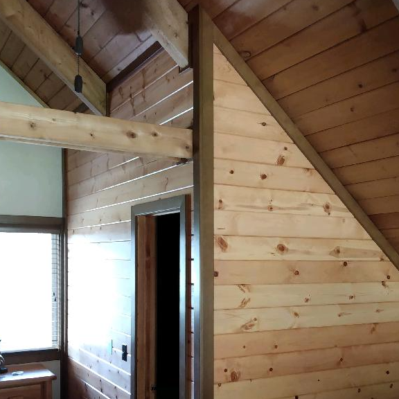 A room with wood paneling and a ceiling fan