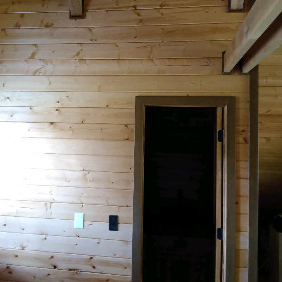 There is a door in the middle of a wooden room.