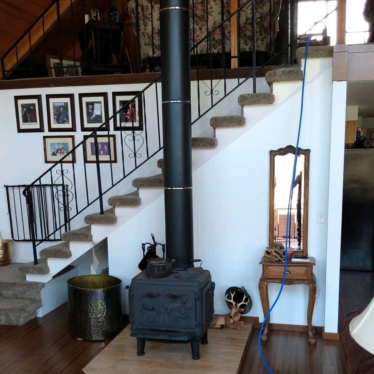 A wood stove in a living room next to stairs