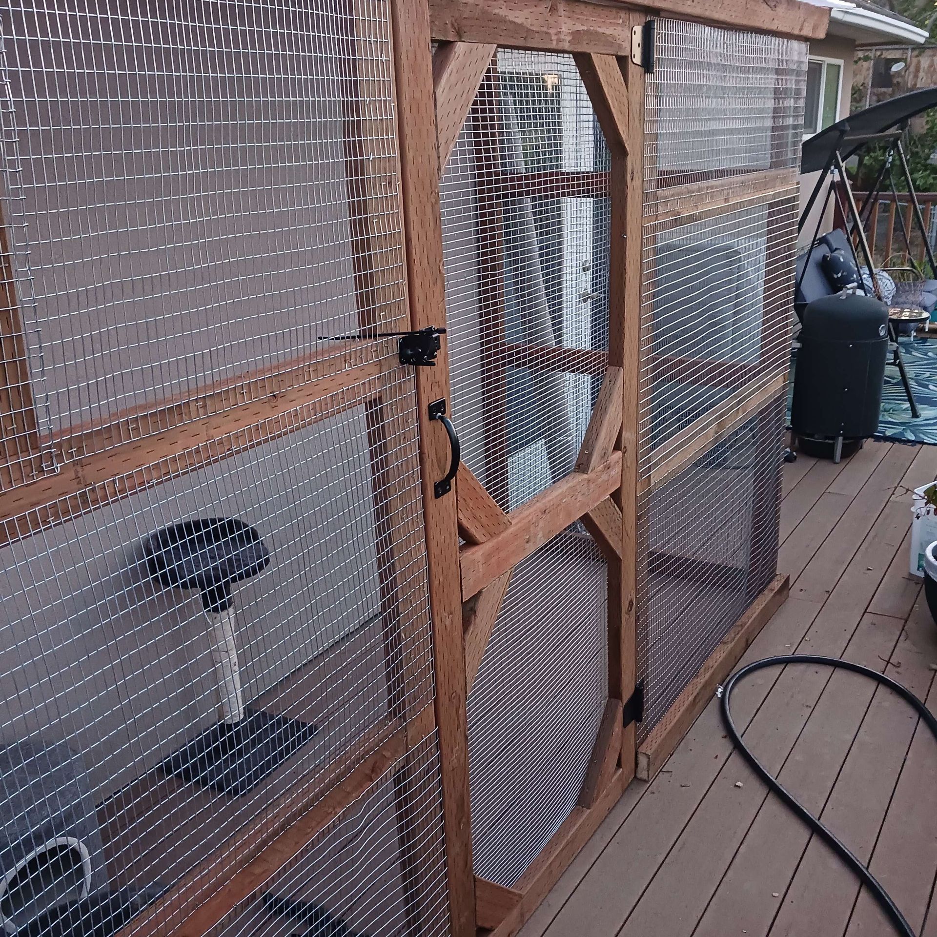 A wooden fence with a hose attached to it