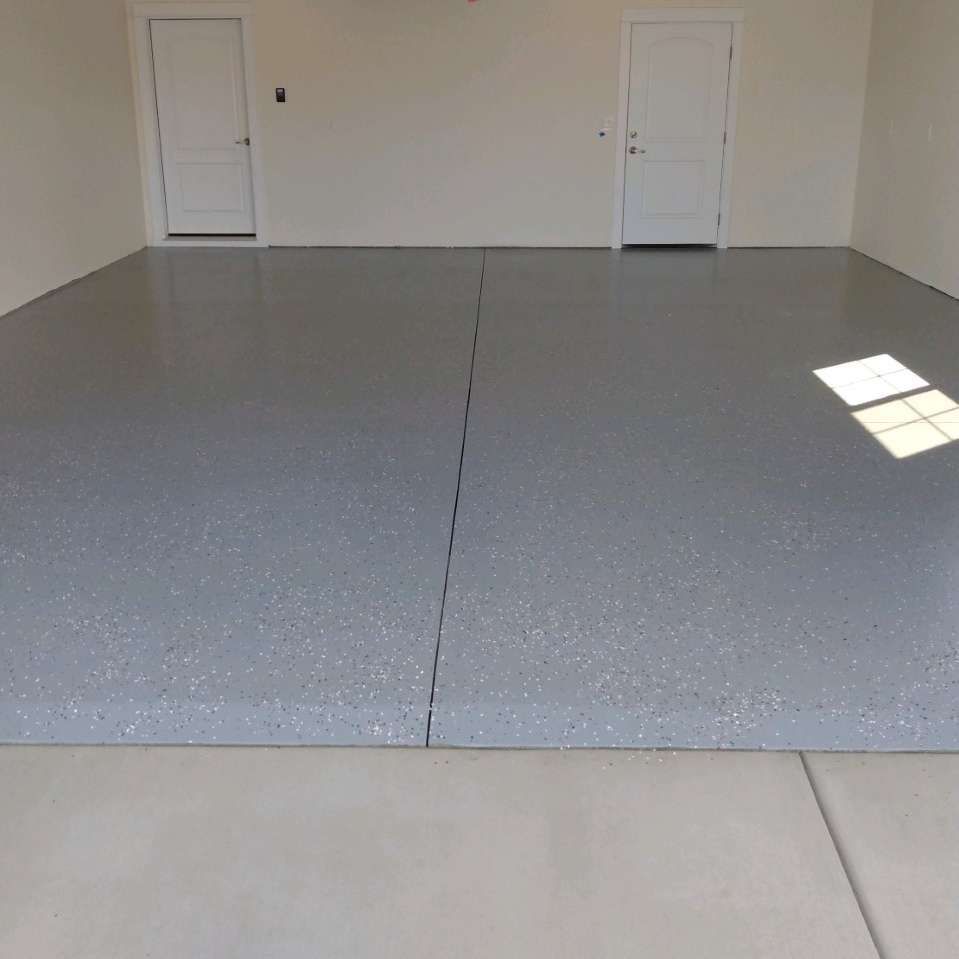 A garage with a gray concrete floor and white walls.