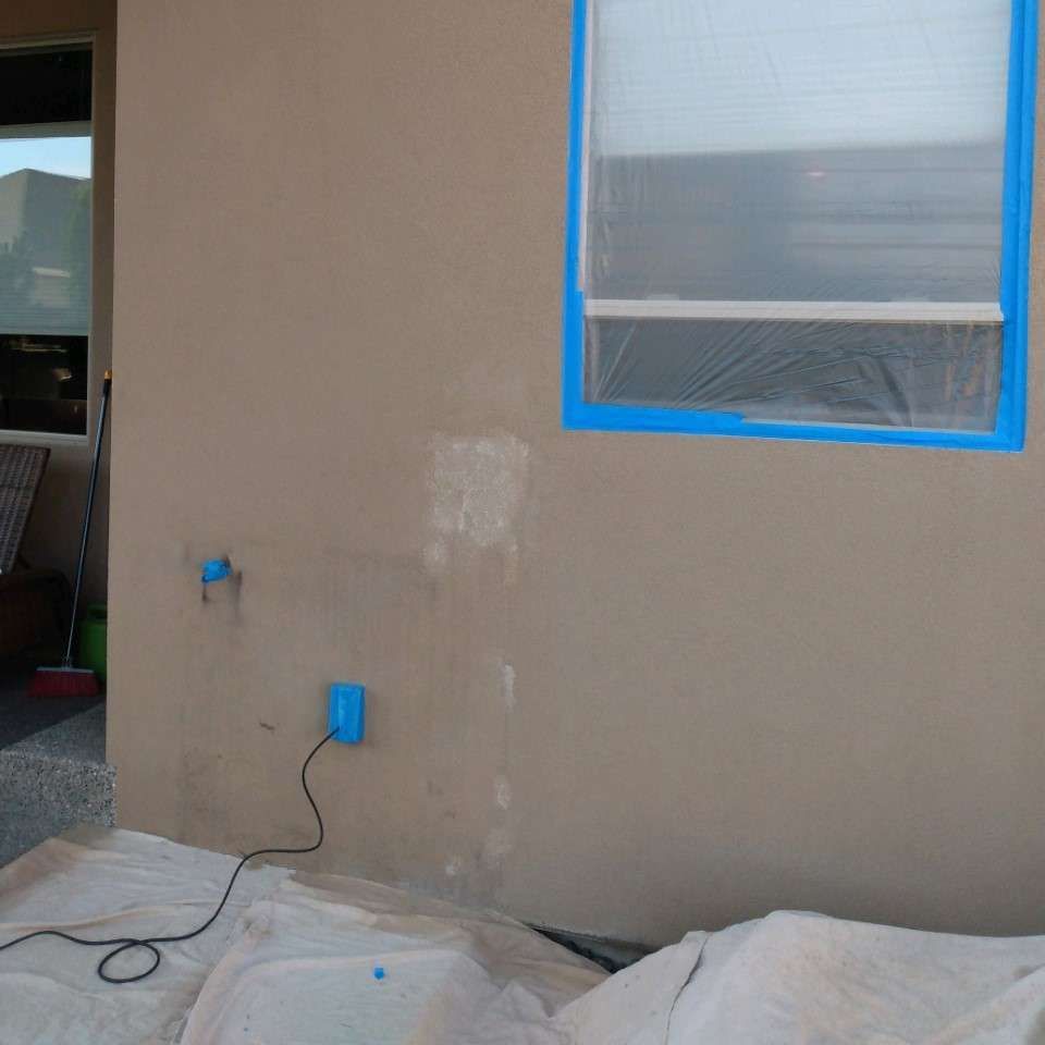 A window is taped to a wall with blue tape