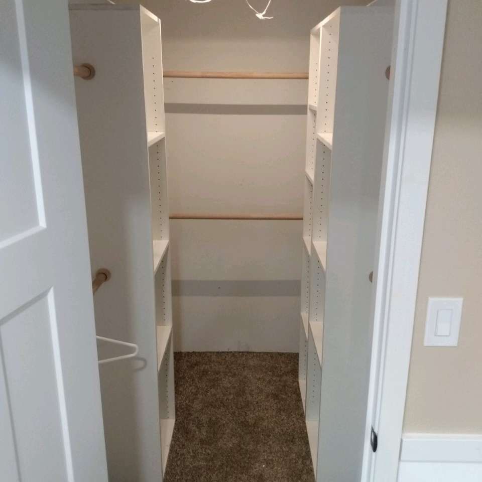 A walk in closet with shelves and a light switch