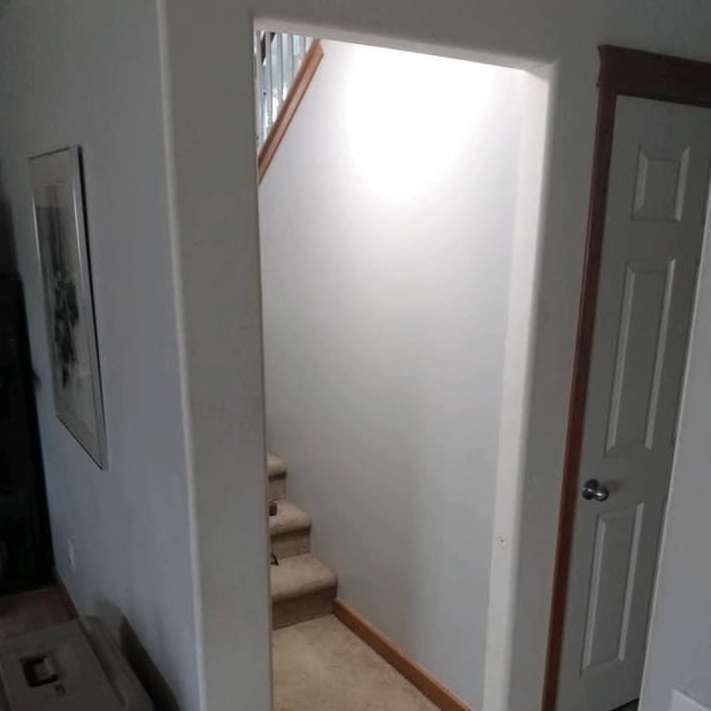 A hallway with stairs leading up to the second floor of a house.