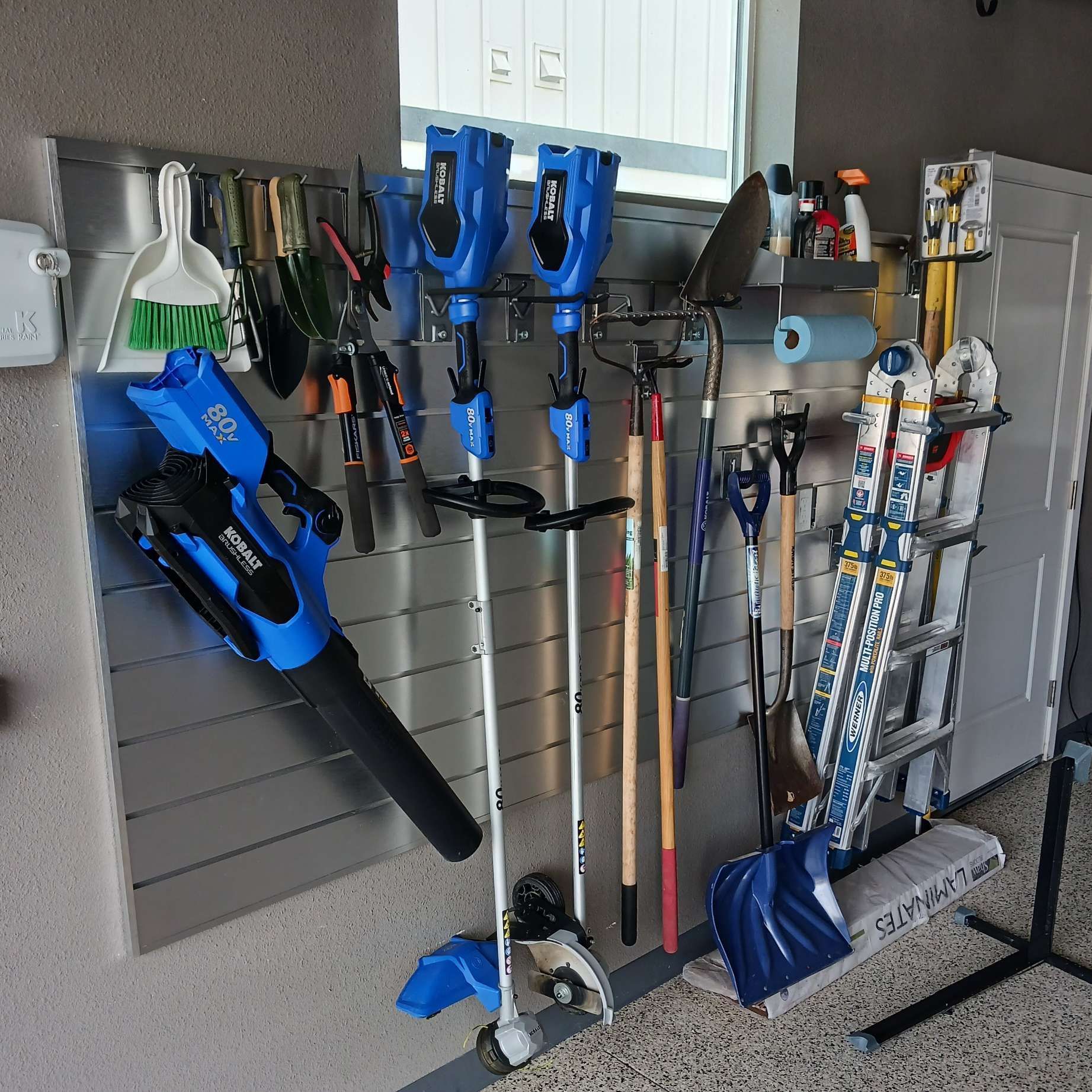 A bunch of tools are hanging on a wall in a garage