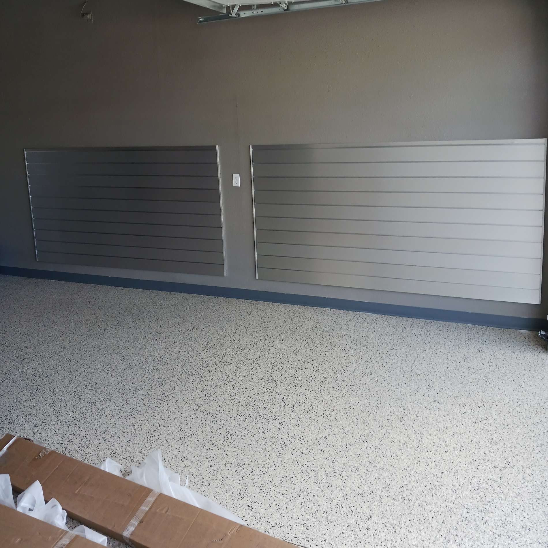 A garage with a gray wall and a white floor