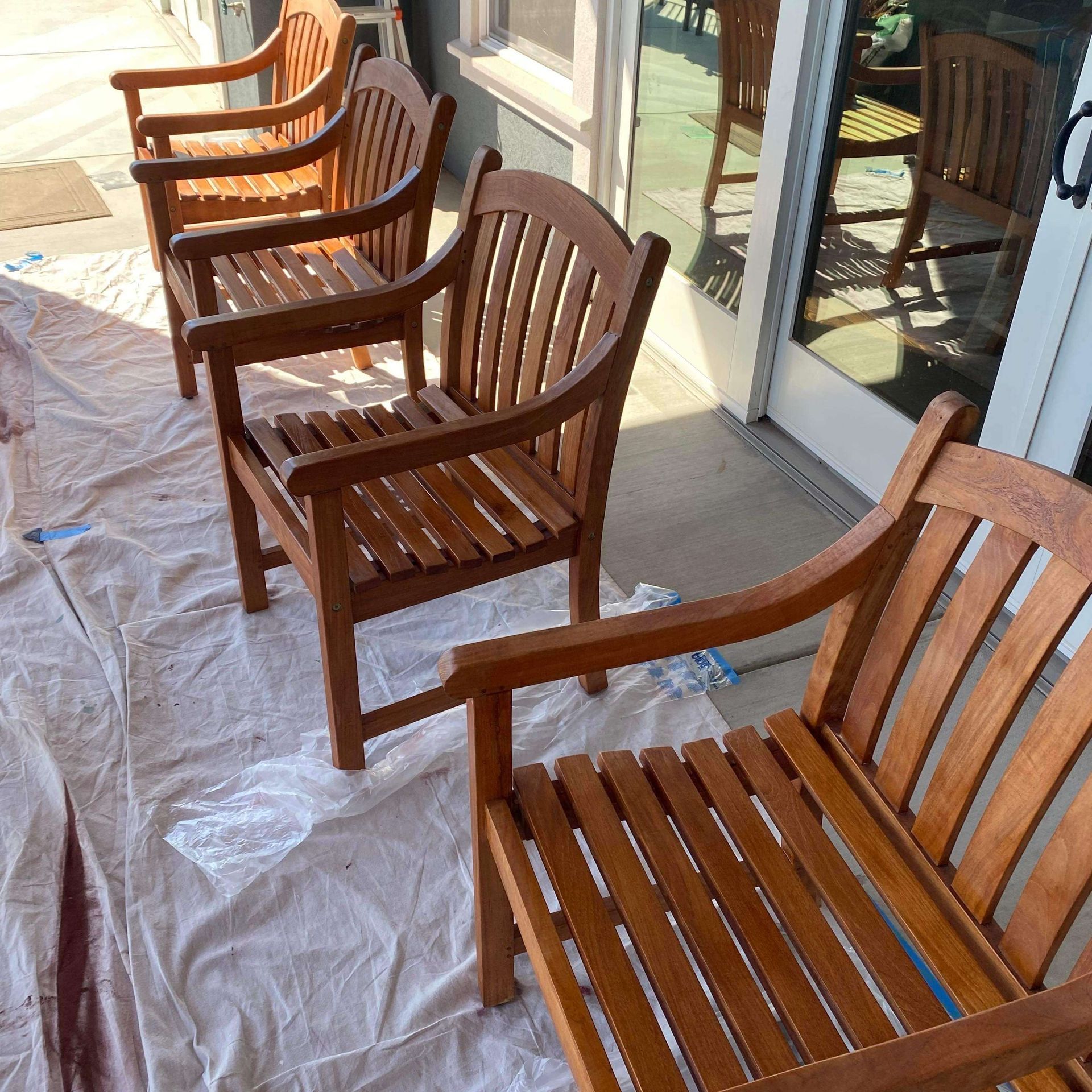 A row of wooden chairs are sitting on a white tarp